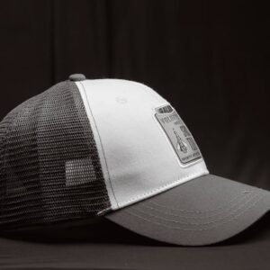 Black and white mesh baseball cap with patch detail in a studio side view shot.